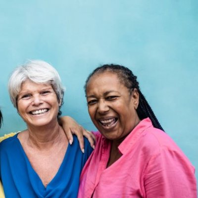 Three women of different ethnicities posing and smiling 